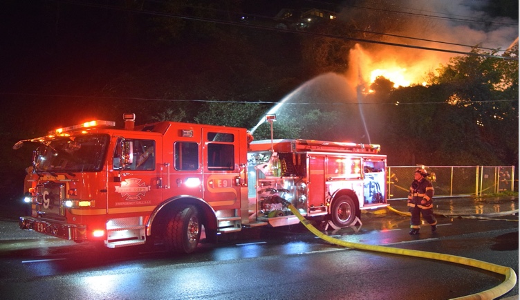 red fire truck at night spraying water